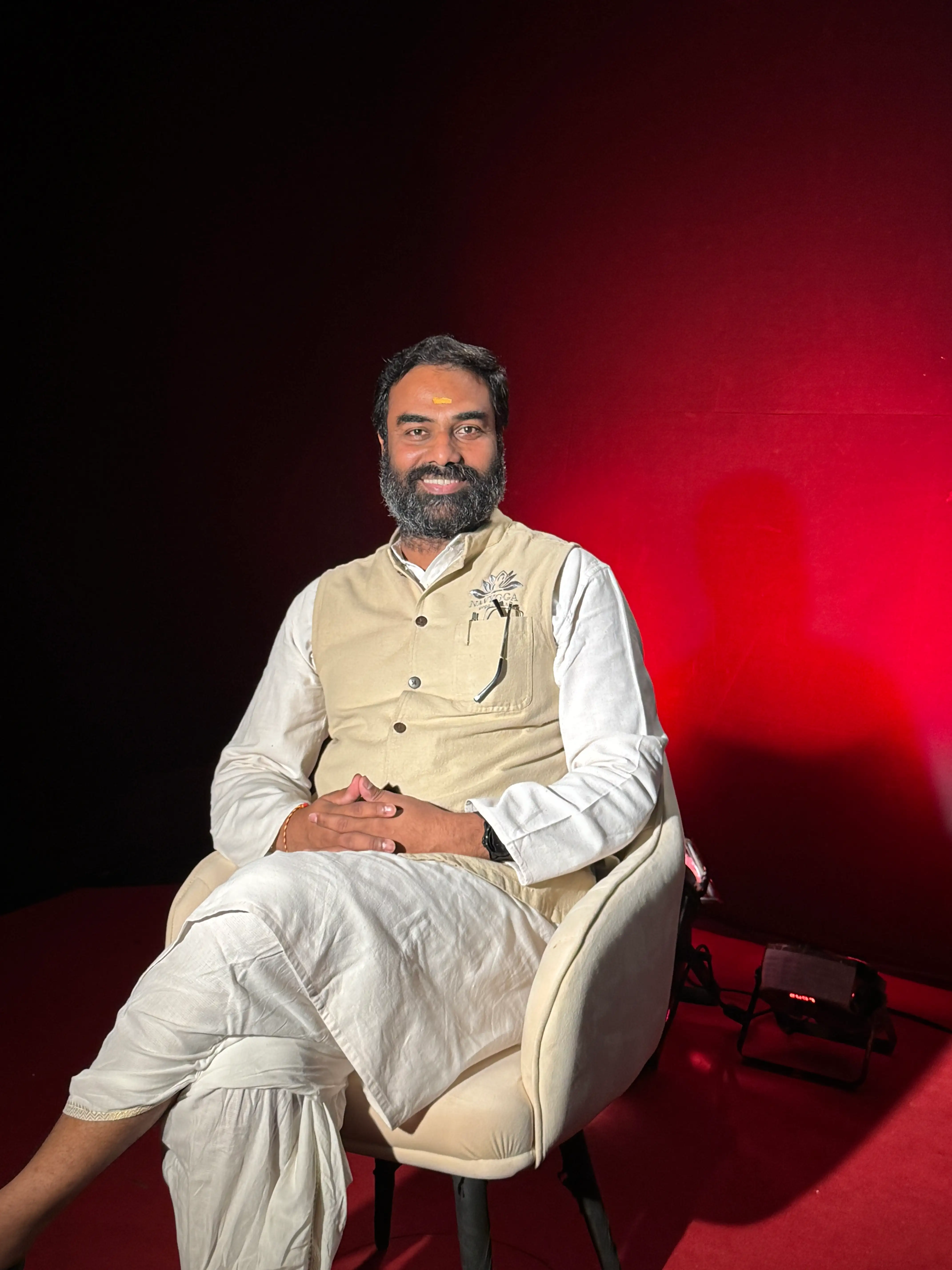 Naveen K. Kolli in a podcast room — Founder, Navyoga Wellness